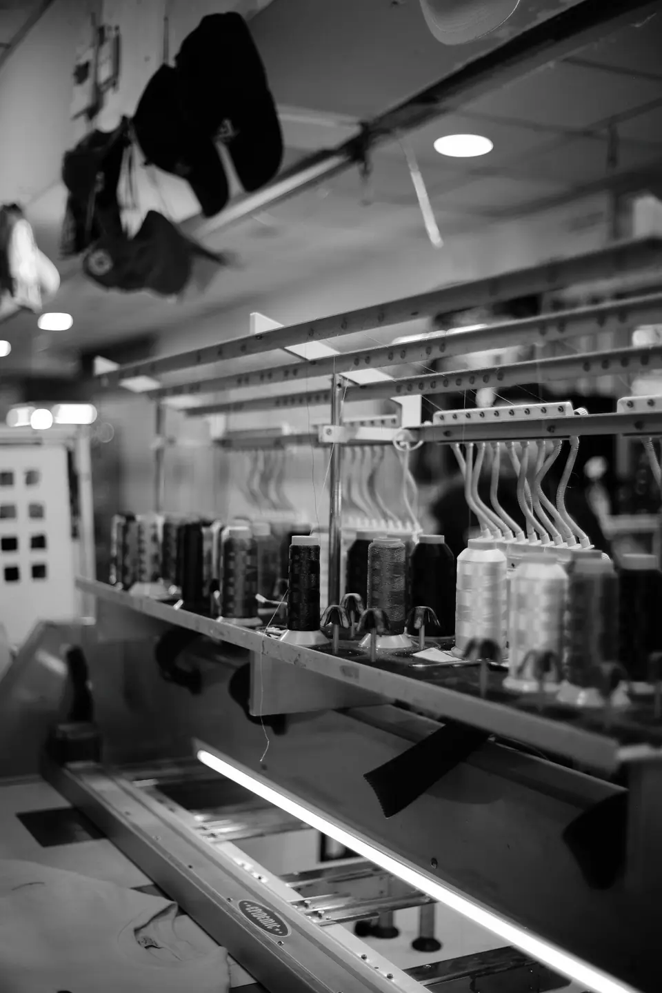 Máquina de bordar industrial con varios cabezales y conos de hilo